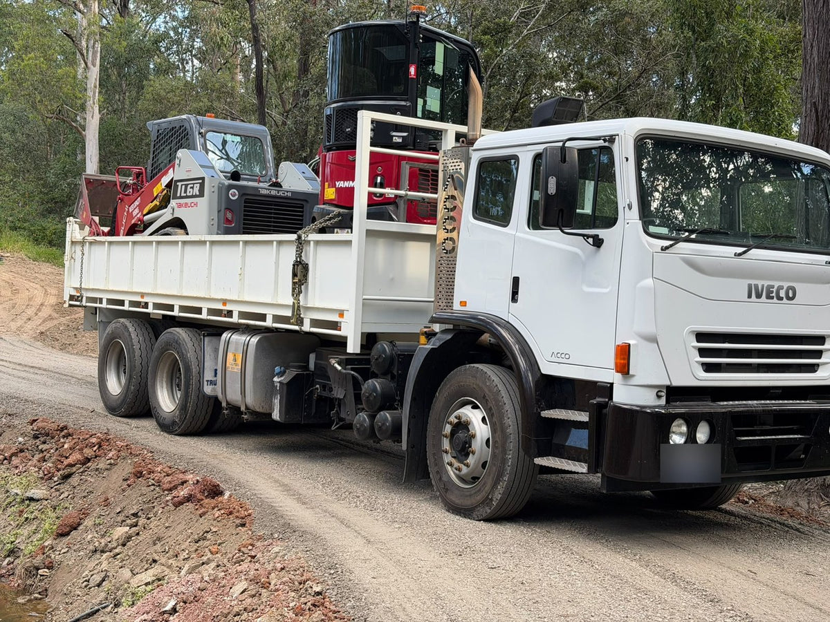 Iveco Acco tipper carrying an excavator and track loader – serviced by Bells Diesel Repairs in Logan
